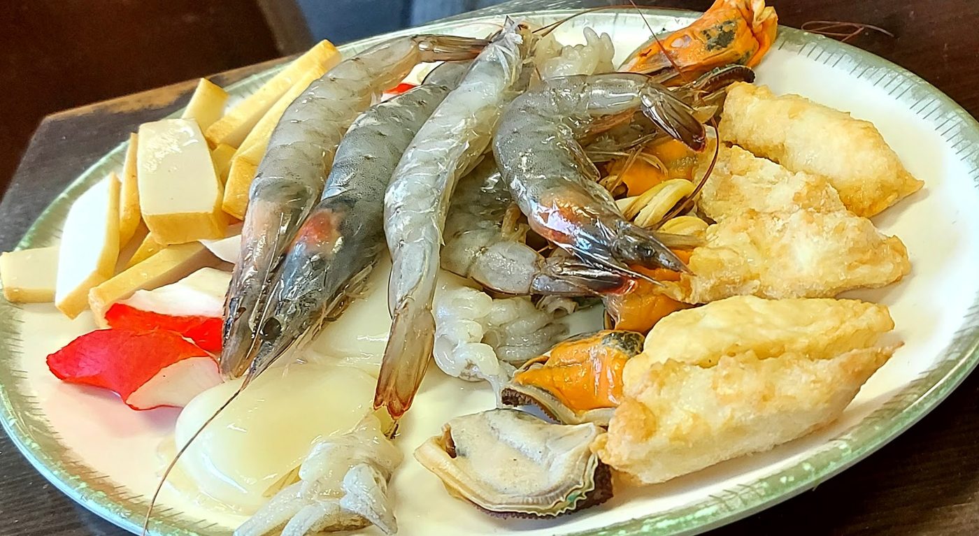 A platter of raw prawns, squid, mussels and scallops with crab stick and golden fried pieces