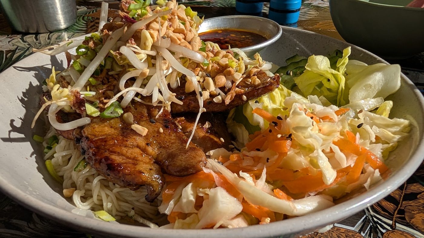 Char-grilled meat over noodles with bean sprouts, crushed peanuts and fried shallots